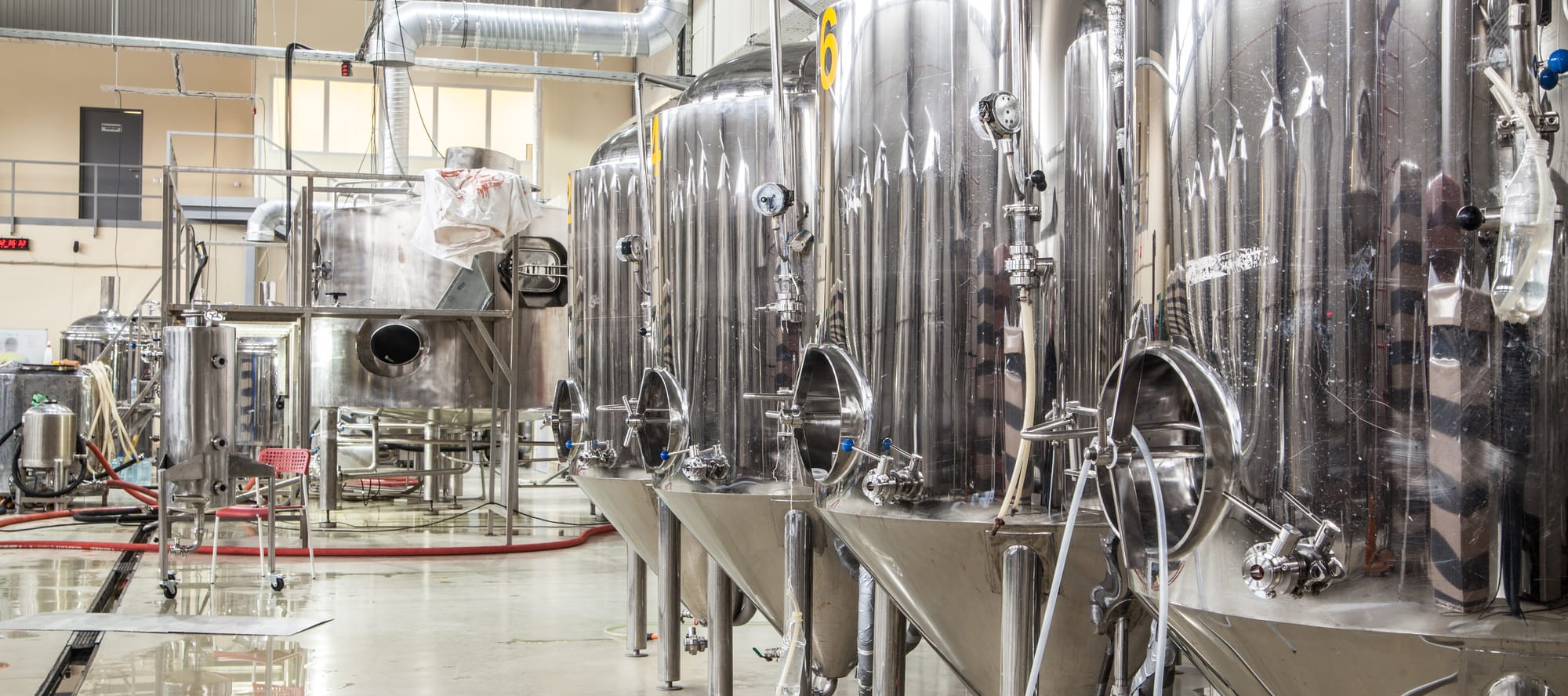 Modern brewery with brewing kettles, tubes and tanks made of stainless steel.