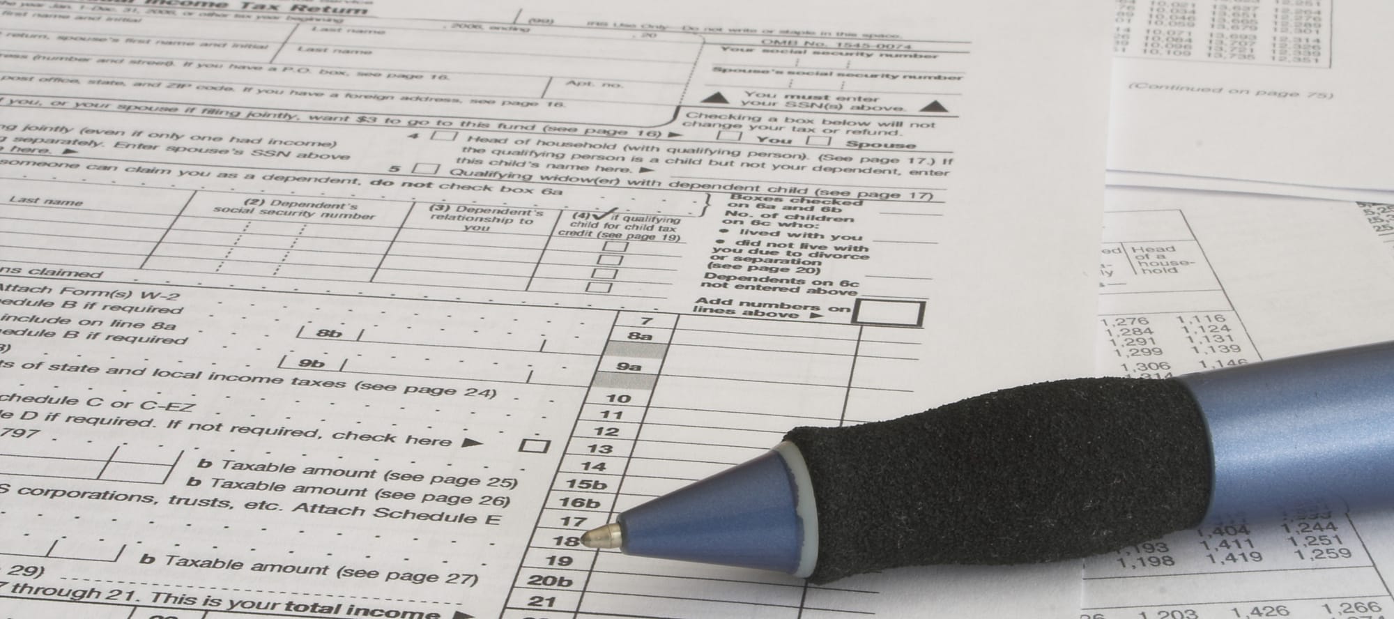 Photo of a pen on top of tax forms