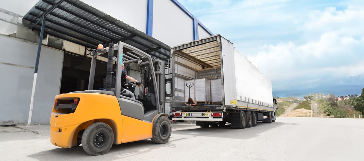 Photo of a skid loader loading a semi truck