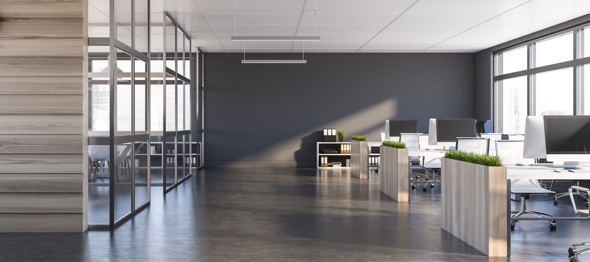 Corporate office with desks, monitors, and a glass conference room.