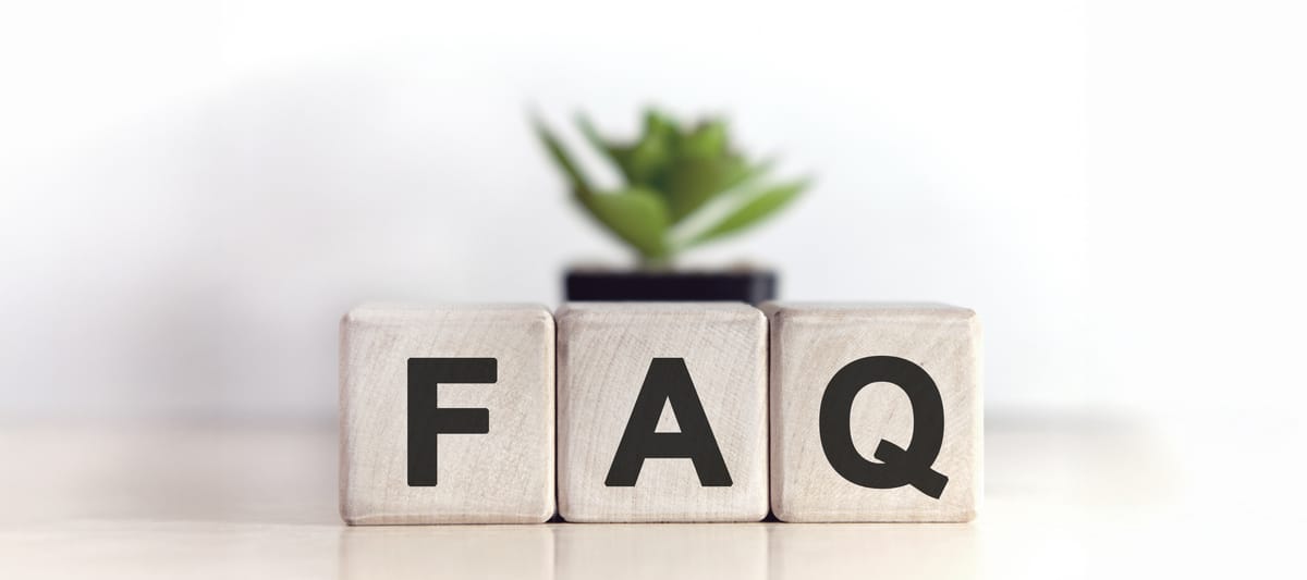 FAQ concept on wooden cubes and flower in a pot in the background