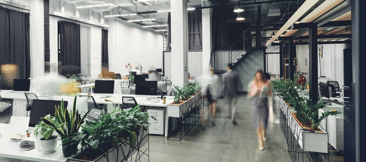 Modern open space office interior with blurred workers